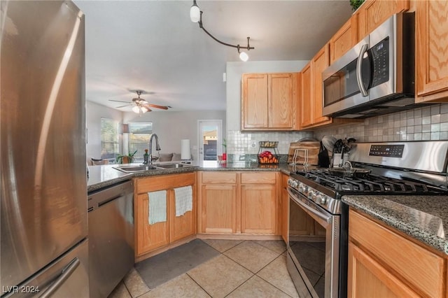 kitchen with ceiling fan, sink, tasteful backsplash, light tile patterned floors, and appliances with stainless steel finishes