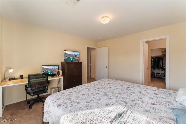 bedroom with a spacious closet, a closet, and light colored carpet