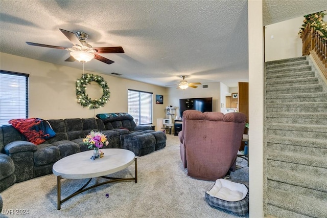 living room featuring ceiling fan, carpet, and a textured ceiling