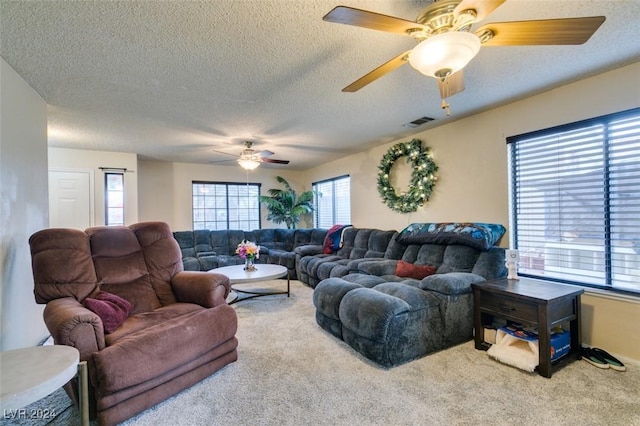 living room with carpet flooring, a textured ceiling, and ceiling fan