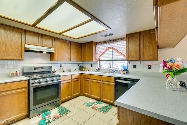 kitchen with tasteful backsplash, stainless steel range with gas stovetop, sink, black dishwasher, and light tile patterned flooring