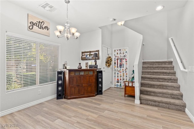 interior space with a notable chandelier, visible vents, stairway, light wood-type flooring, and baseboards