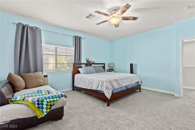 carpeted bedroom featuring a ceiling fan, visible vents, and baseboards