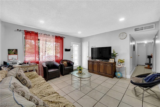 tiled living room featuring a textured ceiling