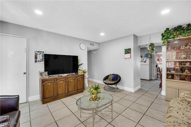 tiled living room featuring a textured ceiling