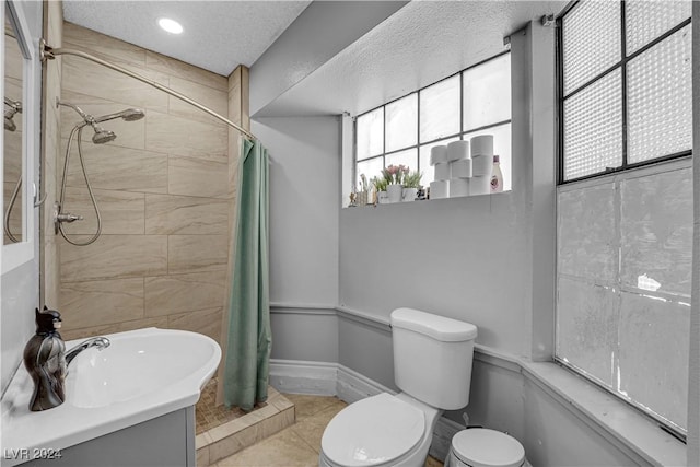 bathroom featuring toilet, tile patterned flooring, a textured ceiling, and a shower with shower curtain