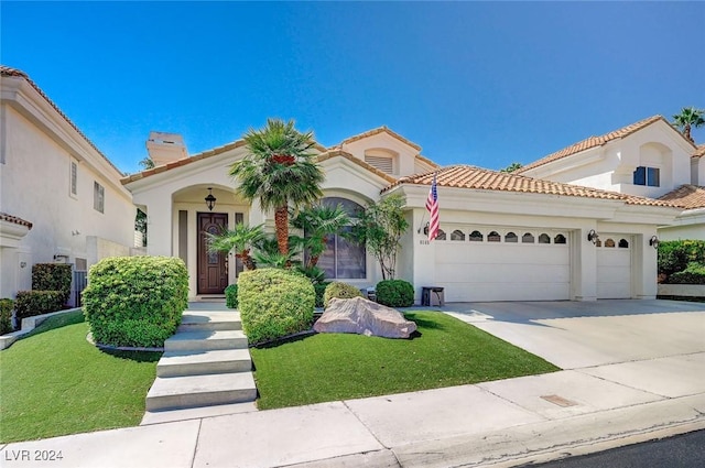 mediterranean / spanish-style house featuring a garage and a front lawn