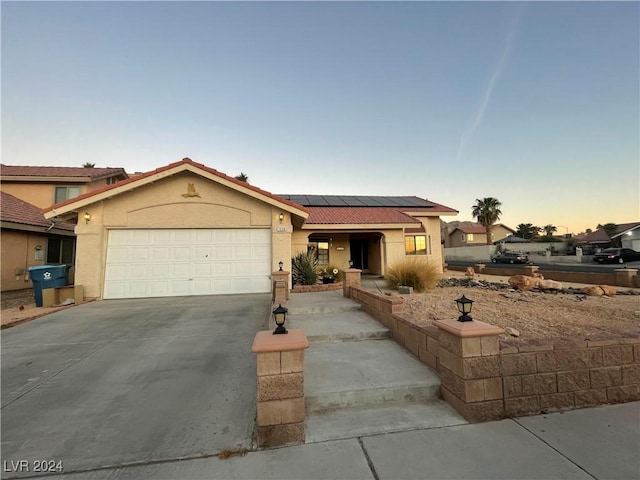 view of front of home with solar panels and a garage