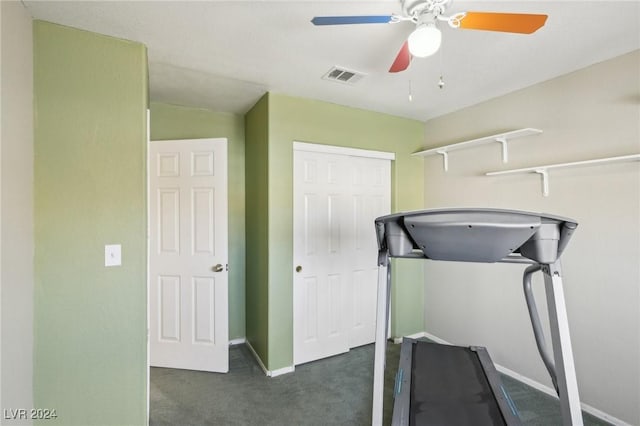 exercise room featuring dark carpet