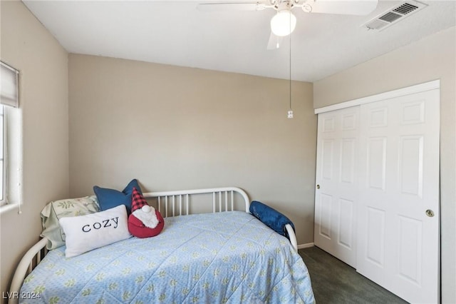 carpeted bedroom featuring ceiling fan and a closet