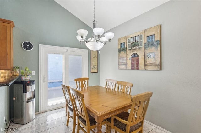 tiled dining space featuring vaulted ceiling and a chandelier