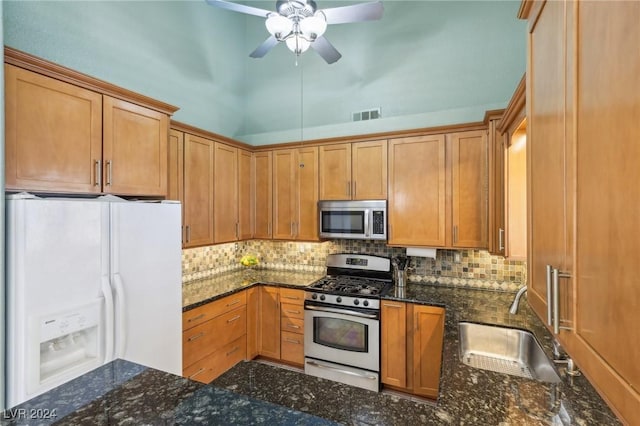 kitchen featuring tasteful backsplash, appliances with stainless steel finishes, sink, and dark stone countertops