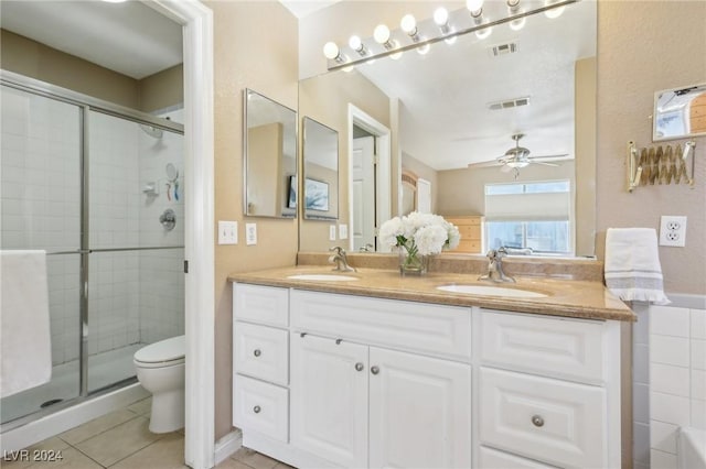 bathroom featuring toilet, vanity, tile patterned floors, and walk in shower