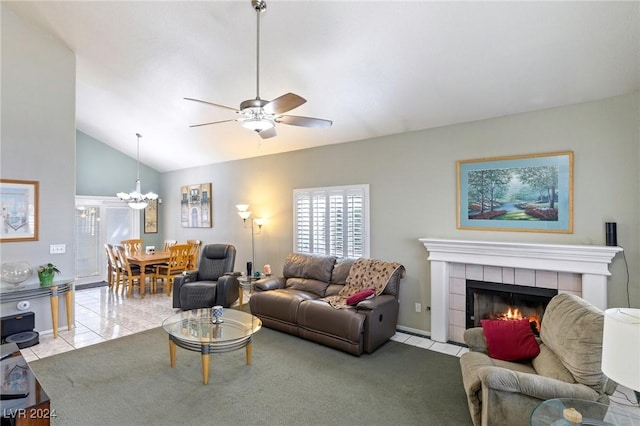 living room featuring ceiling fan with notable chandelier, vaulted ceiling, a tile fireplace, and light tile patterned floors