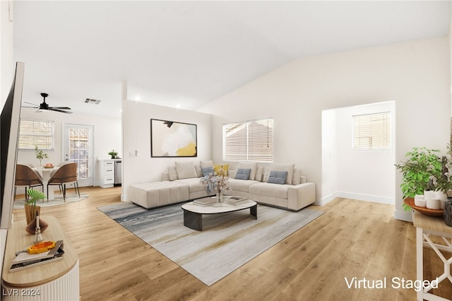 living room featuring ceiling fan, light hardwood / wood-style flooring, and lofted ceiling