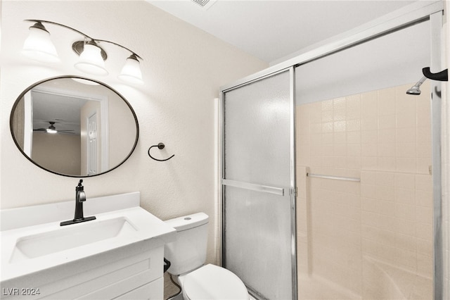 bathroom featuring vanity, ceiling fan, toilet, and walk in shower