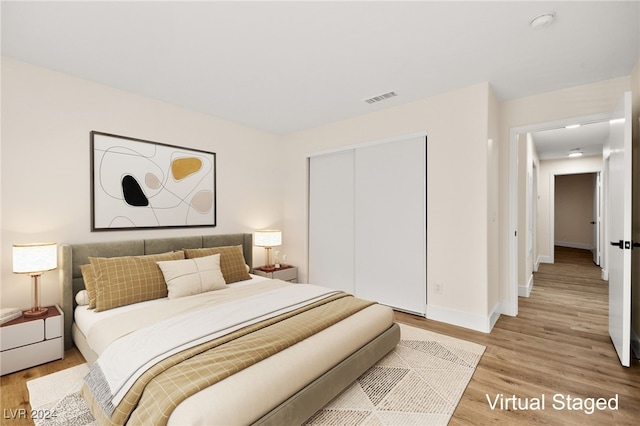 bedroom with light hardwood / wood-style flooring and a closet