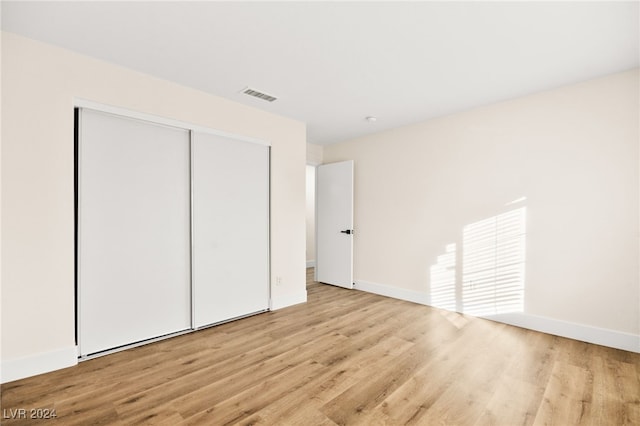 unfurnished bedroom featuring a closet and light hardwood / wood-style floors