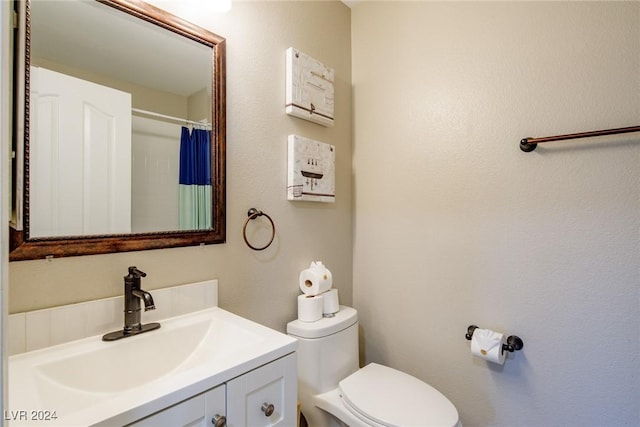 bathroom with vanity, toilet, and curtained shower