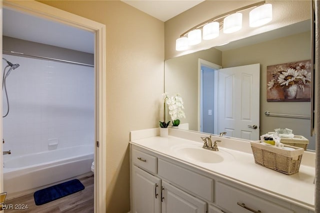 full bathroom featuring hardwood / wood-style floors, vanity, toilet, and shower / bath combination