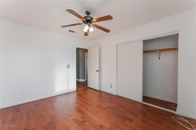 unfurnished bedroom featuring dark hardwood / wood-style flooring, a closet, and ceiling fan