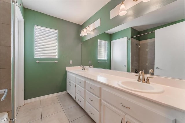 bathroom with a tile shower, vanity, tile patterned floors, and a wealth of natural light