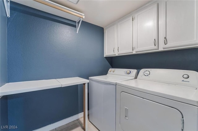 washroom featuring cabinets, light tile patterned floors, and washer and dryer