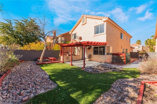 back of property with a lawn, a patio area, and a pergola