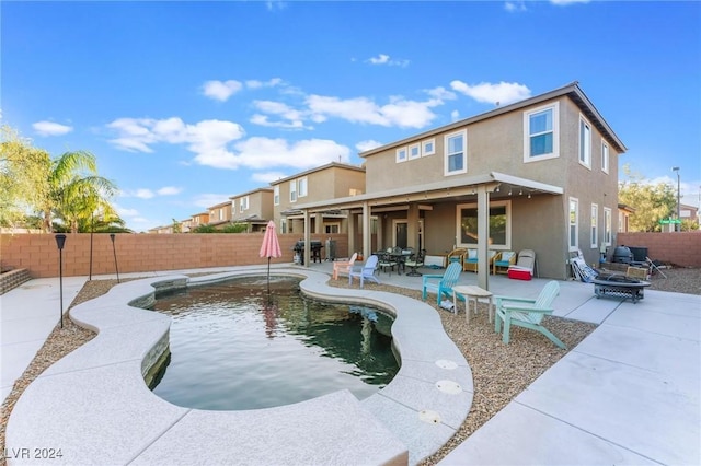 back of house featuring a patio, a fenced in pool, and a fire pit