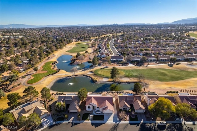 drone / aerial view with view of golf course, a residential view, and a water and mountain view