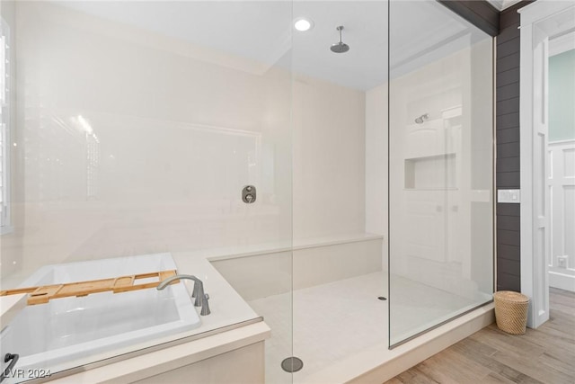 bathroom featuring sink, wood-type flooring, and shower with separate bathtub