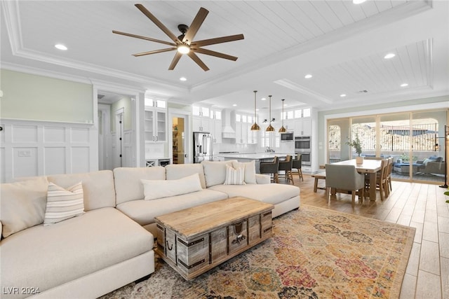 living room with light hardwood / wood-style flooring, ceiling fan, ornamental molding, and wood ceiling