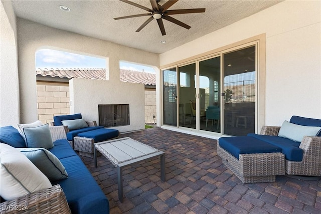 view of patio featuring ceiling fan and an outdoor fireplace