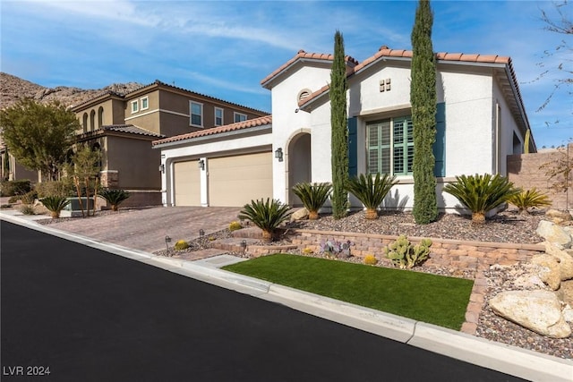 mediterranean / spanish-style home with a garage