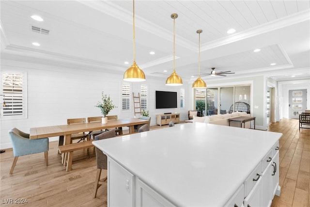 kitchen with ornamental molding, ceiling fan, decorative light fixtures, light hardwood / wood-style floors, and white cabinetry