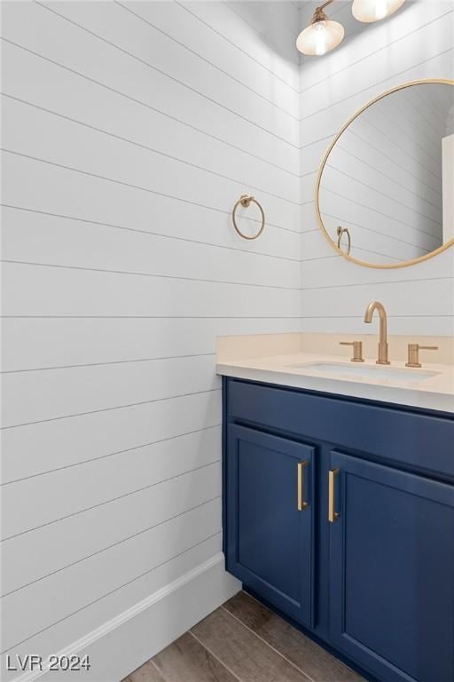 bathroom featuring vanity, wood-type flooring, and wooden walls