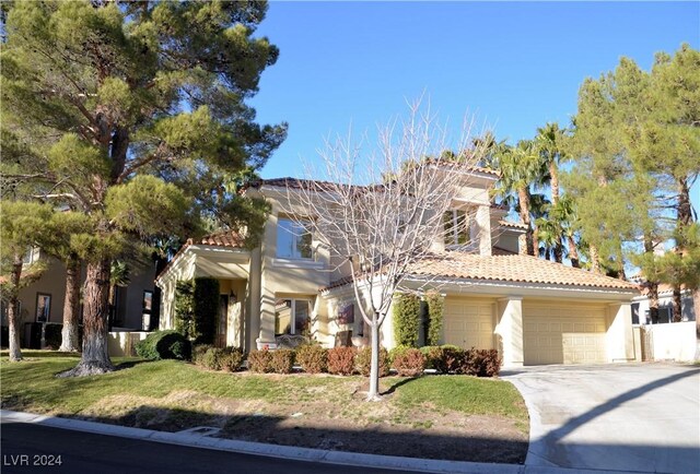 mediterranean / spanish-style house featuring a front yard and a garage