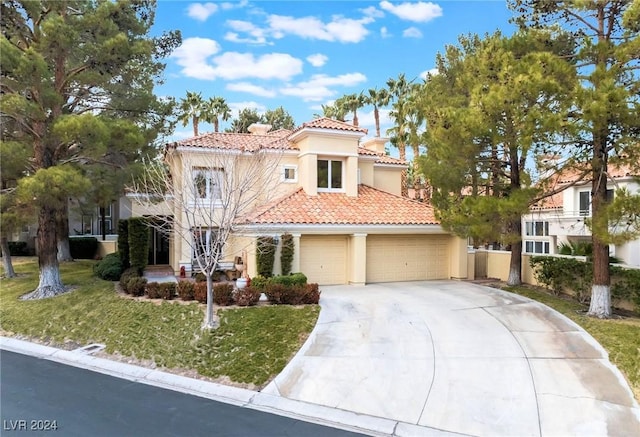 mediterranean / spanish home with a garage and a front lawn