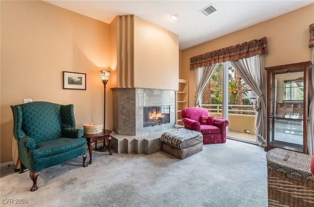 sitting room featuring a tile fireplace and carpet