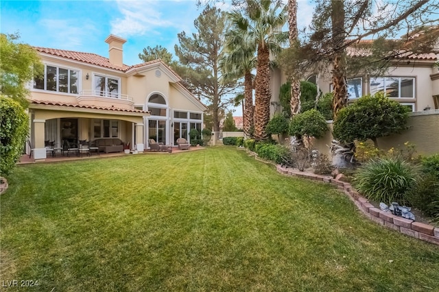 rear view of property with a yard and a patio area