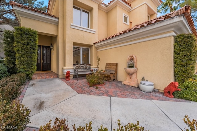 view of exterior entry featuring a patio area