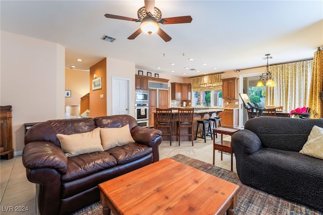 living room featuring light tile patterned floors and ceiling fan