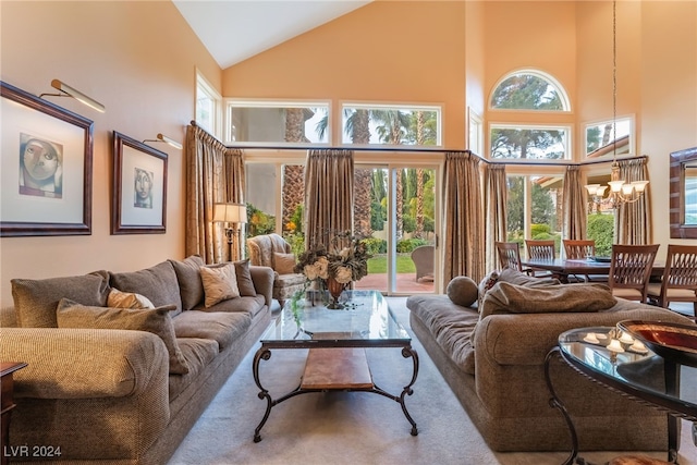 carpeted living room featuring high vaulted ceiling and a chandelier