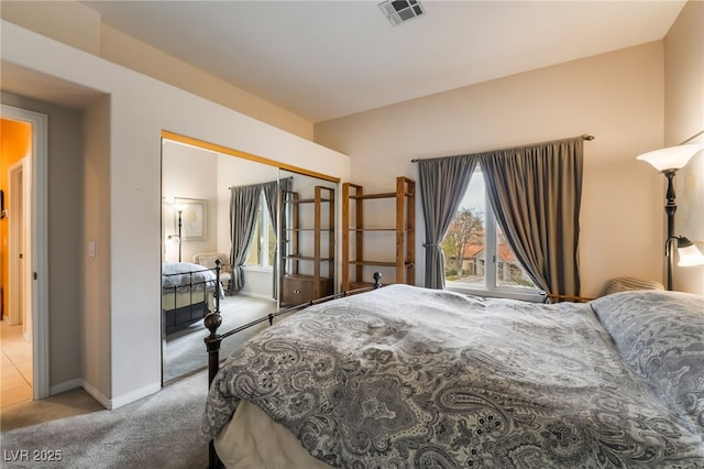 bedroom with light carpet and a closet