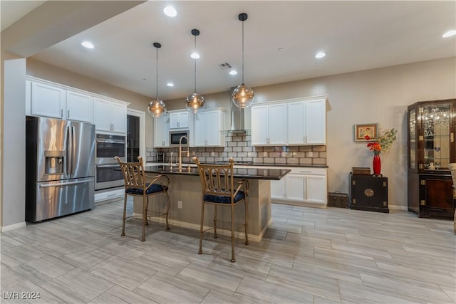 kitchen featuring dark countertops, visible vents, backsplash, a kitchen bar, and appliances with stainless steel finishes