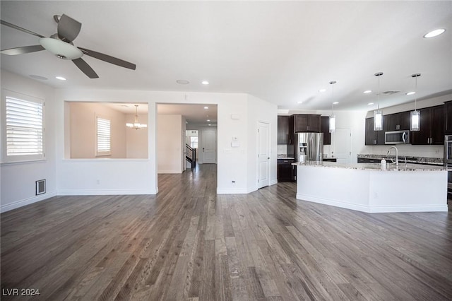 kitchen featuring light stone counters, dark hardwood / wood-style flooring, pendant lighting, and appliances with stainless steel finishes