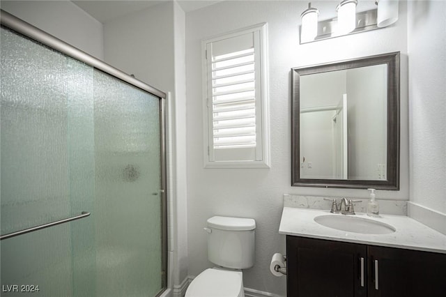 bathroom featuring vanity, toilet, and an enclosed shower