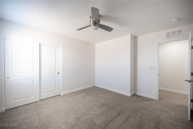 unfurnished bedroom with ceiling fan, a closet, and light colored carpet