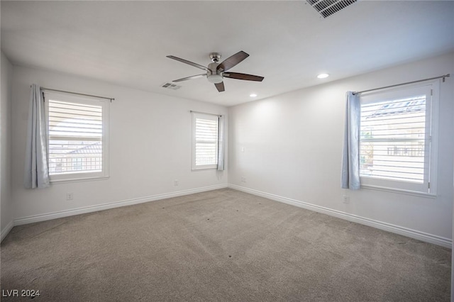 spare room with ceiling fan and light colored carpet