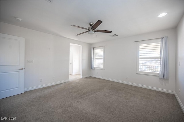 unfurnished room with ceiling fan and light colored carpet